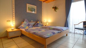 Una camera da letto con un letto in legno, due comodini con lampade, un quadro appeso al muro e una finestra con tende.