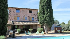 A stone building with a tiled roof, a swimming pool, and outdoor seating. - Private Pool in Provence (La Motte)