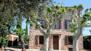 A stone building with a central door, windows, and a covered porch. - Private Pool in Provence (La Motte)