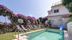A swimming pool with lounge chairs, a slide, and a building with a balcony. - Elegant Seaside Villa in Eze (Èze)