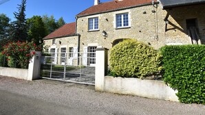 A stone building with a red-tiled roof, a gated entrance, and a well-maintained hedge. - Holiday Home Vault-de-lugny Near Forest (Vault-de-Lugny)