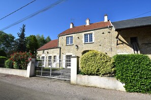 A stone building with a red-tiled roof, a gated entrance, and a well-maintained hedge. - Holiday Home Vault-de-lugny Near Forest (Vault-de-Lugny)