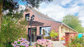 A building with a brick facade, large windows, and outdoor seating. - Nature Hideaway in St Germain du Pert (Saint-Germain-du-Pert)