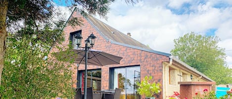 A building with a brick facade, large windows, and outdoor seating.