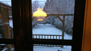 A snow-covered deck with a wooden railing and a snow-covered ground.