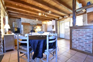 A rustic dining area with a wooden ceiling, stone walls, and a tiled floor. - Holiday Home in Gramat With Private Pool (Gramat)