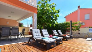 An outdoor seating area with lounge chairs and a barbecue grill. - Villa 1771 (Vodnjan)
