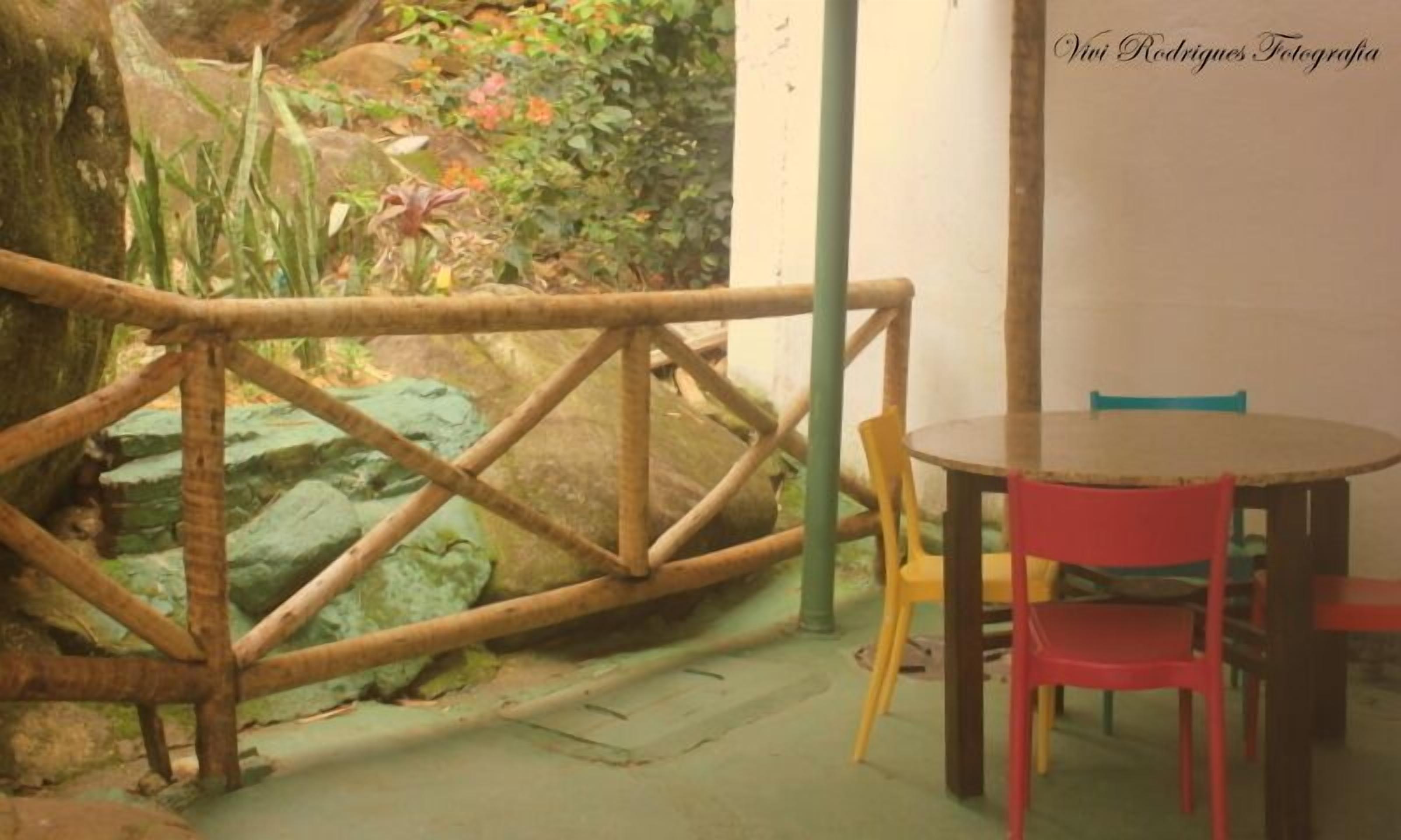 Une pièce avec une clôture en bois, une table ronde et deux chaises.