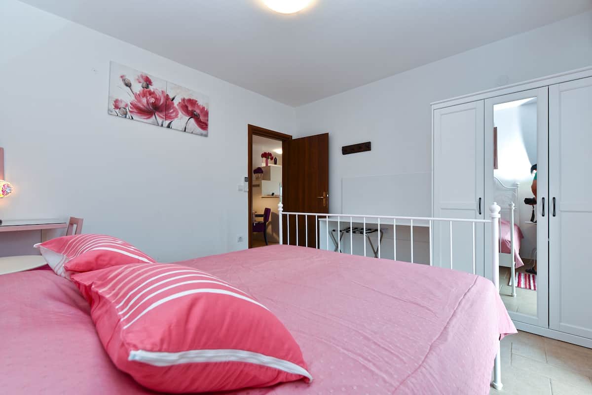 Ein Schlafzimmer mit einem großen Bett, einem Kleiderschrank und einer Tür zum Badezimmer.