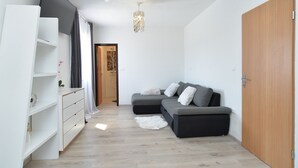 A modern living room with a grey sectional sofa, white storage unit, and a wooden door. - House 1790 (Medulin)