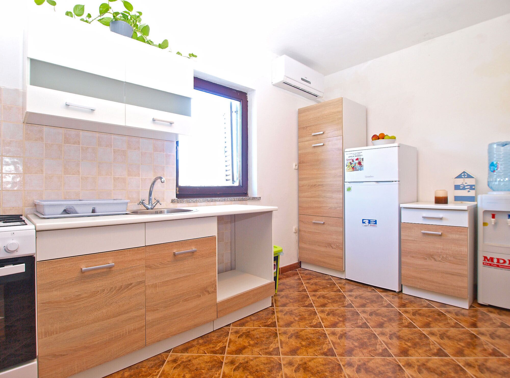 A modern kitchen with a sink, stove, and cabinets.