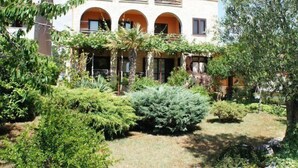 A courtyard with a building featuring arched windows and a stone facade. - Apartment 1803 (Vodnjan)