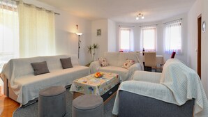 Una sala de estar acogedora con dos sofás, una mesa de centro y una mesa de comedor con sillas.
