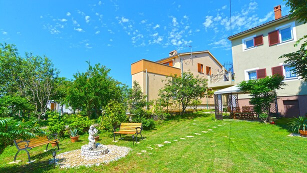 A well-maintained garden with a fountain, benches, and a small statue. - Apartment 1817 (Fazana)