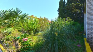A garden with various plants and a fence. - Apartment 1817 (Fazana)