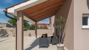 An outdoor patio area with two wicker chairs and a potted plant. - House 1855 (Liznjan)