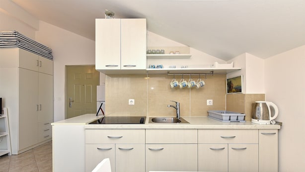 A modern kitchen with light-colored cabinets, a double sink, and a kettle on the countertop. - Apartment 1860 (Medulin)