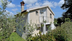 A two-story house with a balcony, surrounded by greenery. - Apartment 1860 (Medulin)