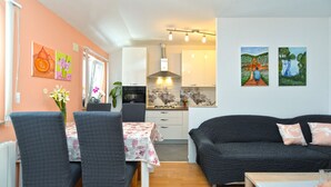 A compact living space with a dining area, kitchenette, and a sofa. - Apartment 1873 (Pula)