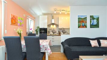 A compact living space with a dining area, kitchenette, and a sofa.