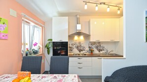 A compact kitchen with white cabinets, a gas stove, and a modern backsplash. - Apartment 1873 (Pula)