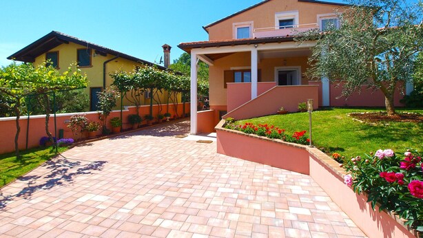 A two-story house with a brick pathway leading to the entrance. - Apartment 1875 (Marcana)