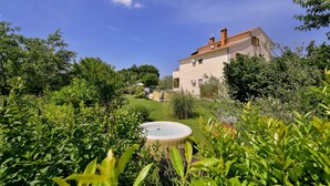 Una casa con un giardino antistante, immersa nel verde.