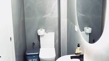 Un baño moderno con inodoro, bidé y lavamanos.