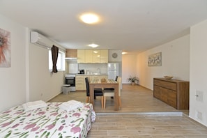 A compact apartment with a kitchenette, a dining area, and a bedroom. - Apartment 1890 (Marcana)