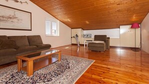 A spacious living room with a wooden ceiling, a large sofa, a coffee table, and a patterned rug. - Apartment 1893 (Fazana)