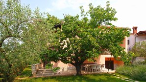 A house with a garden, a patio with outdoor furniture, and a stone staircase leading to the entrance. - Apartment 1893 (Fazana)