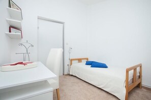 A bedroom with a bed, a desk, and a chair. - Apartment 1893 (Fazana)