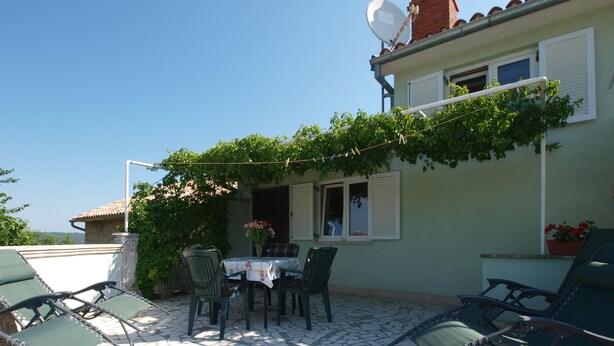 A patio with a table and chairs, a satellite dish, and a potted plant. - Apartment 1895 (Marcana)