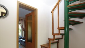 A staircase with a green handrail and wooden steps leading to a landing.