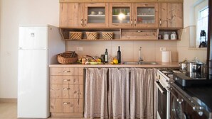 Una cocina con armarios de madera, un refrigerador, un fregadero y una estufa.