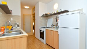 A compact kitchen with a sink, stove, oven, and refrigerator. - Apartment 1905 (Pula)