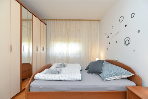 Une chambre à coucher comprenant un lit, une armoire et un mur décoré de motifs circulaires.