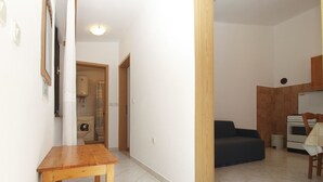 A hallway leading to a kitchen with a dining area and a washing machine in the background. - Apartment 1907 (Zminj)