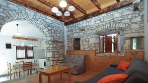 Ein rustikales Interieur mit Stehwänden, Holzmöbeln und einem Steingewölbe.