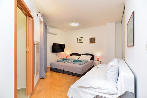 A bedroom with a bed, a TV, and a bedside table with lamps.