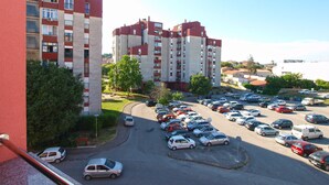 Un immeuble résidentiel à plusieurs étages avec un parking situé à l’avant.