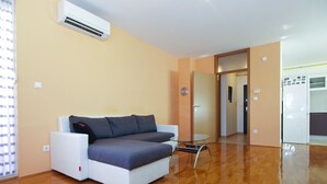 Un salon moderne avec un canapé, une petite table et un appareil de climatisation.