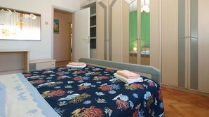 Quarto com cama, guarda-roupa e espelho.