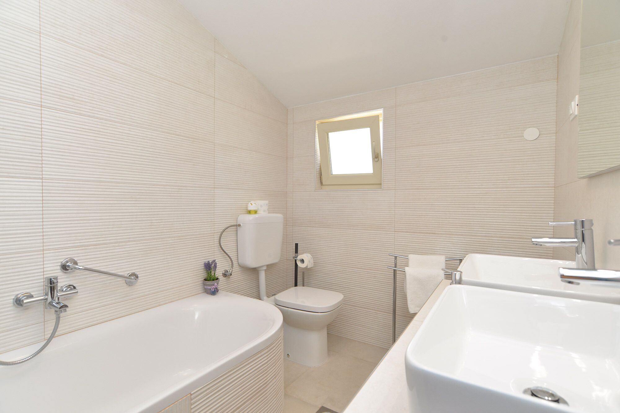 A modern bathroom with a bathtub, a toilet, and a sink.
