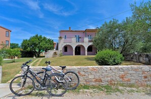 A building with a stone wall and a paved path leading to it.