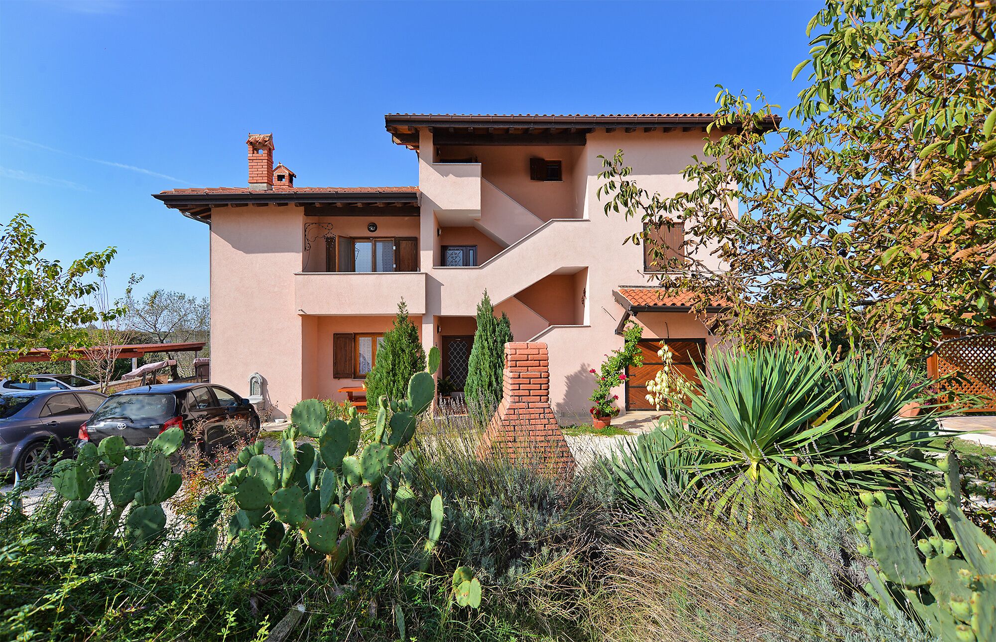 A two-story building with a flat roof and a brick chimney.
