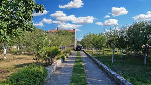 A pathway lined with trees and a building in the distance. - Apartment 1947 (Fazana)