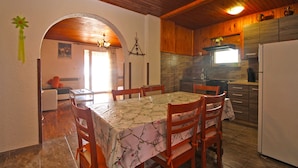 A dining area with a table set for four, wooden chairs, and a chandelier. - Apartment 1954 (Fazana)