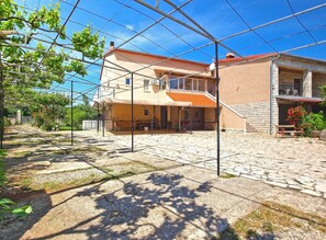 A two-story house with a stone patio and a covered outdoor area. - Apartment 1954 (Fazana)