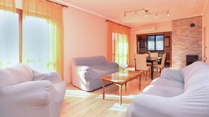 Una sala de estar moderna con un sofá, una mesa de centro y un comedor con mesa y sillas.